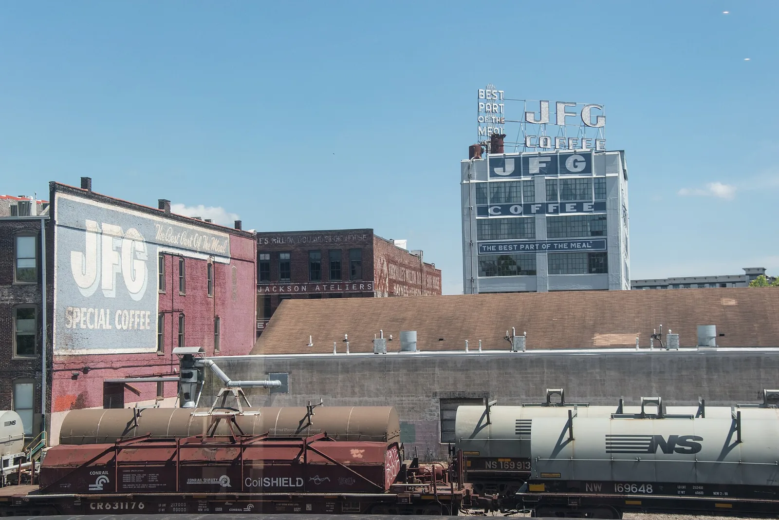 Painted JFG Coffee signs and the old warehouses of Knoxville's Old City, seen across the rail yard.