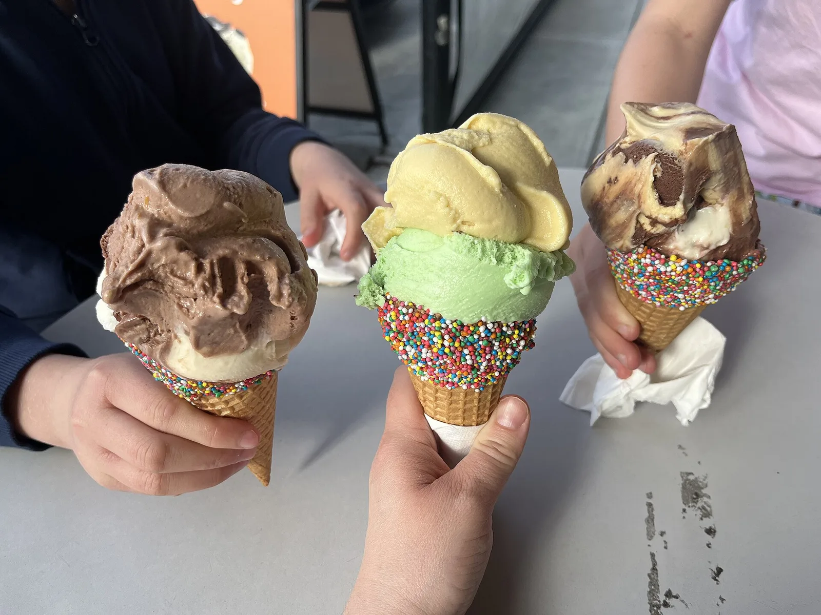 Three scoops of ice cream in sprinkle-dipped cones. The photo was not taken in Knoxville.